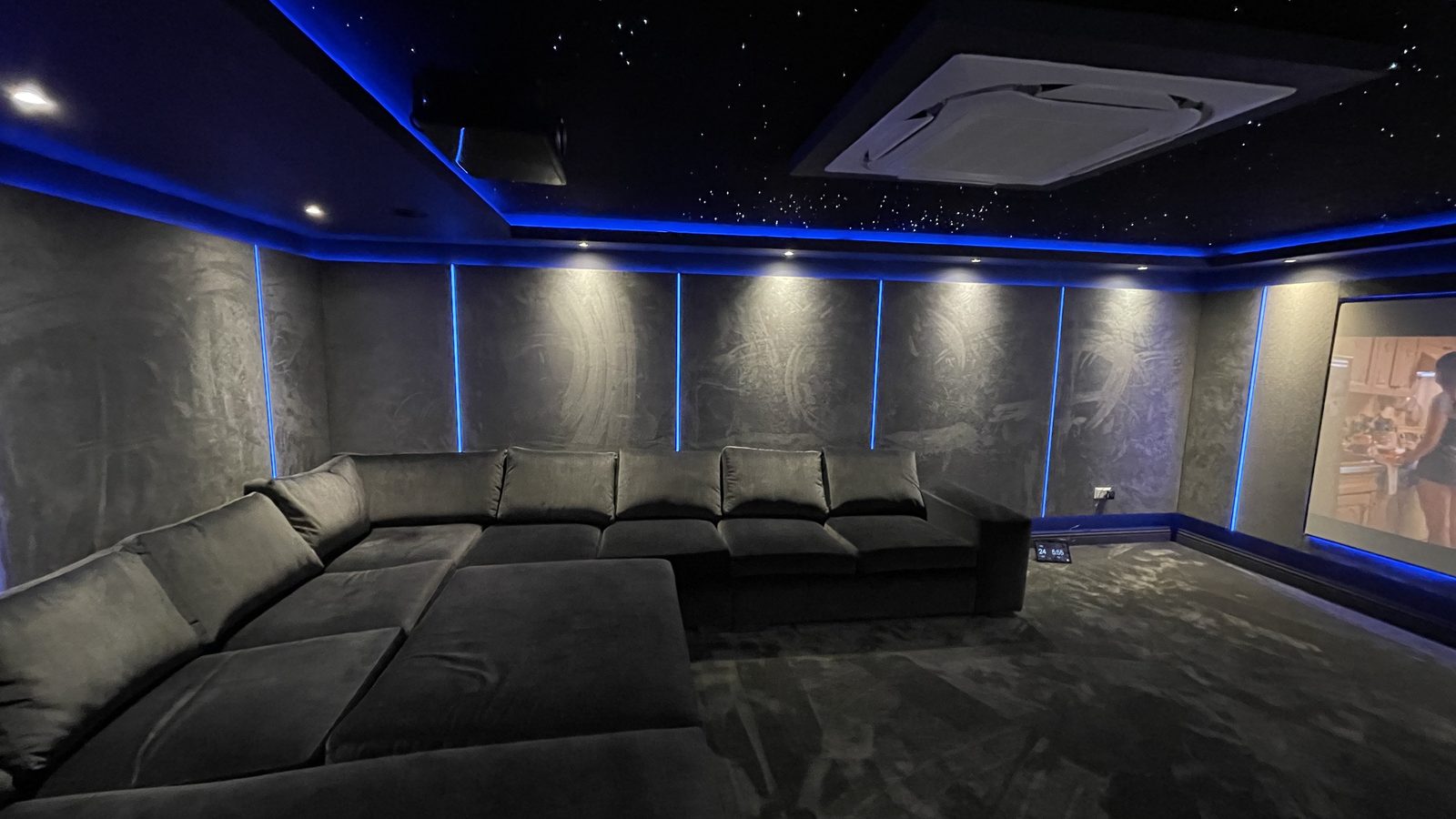 Basement home cinema seating with acoustic wall panels and screen