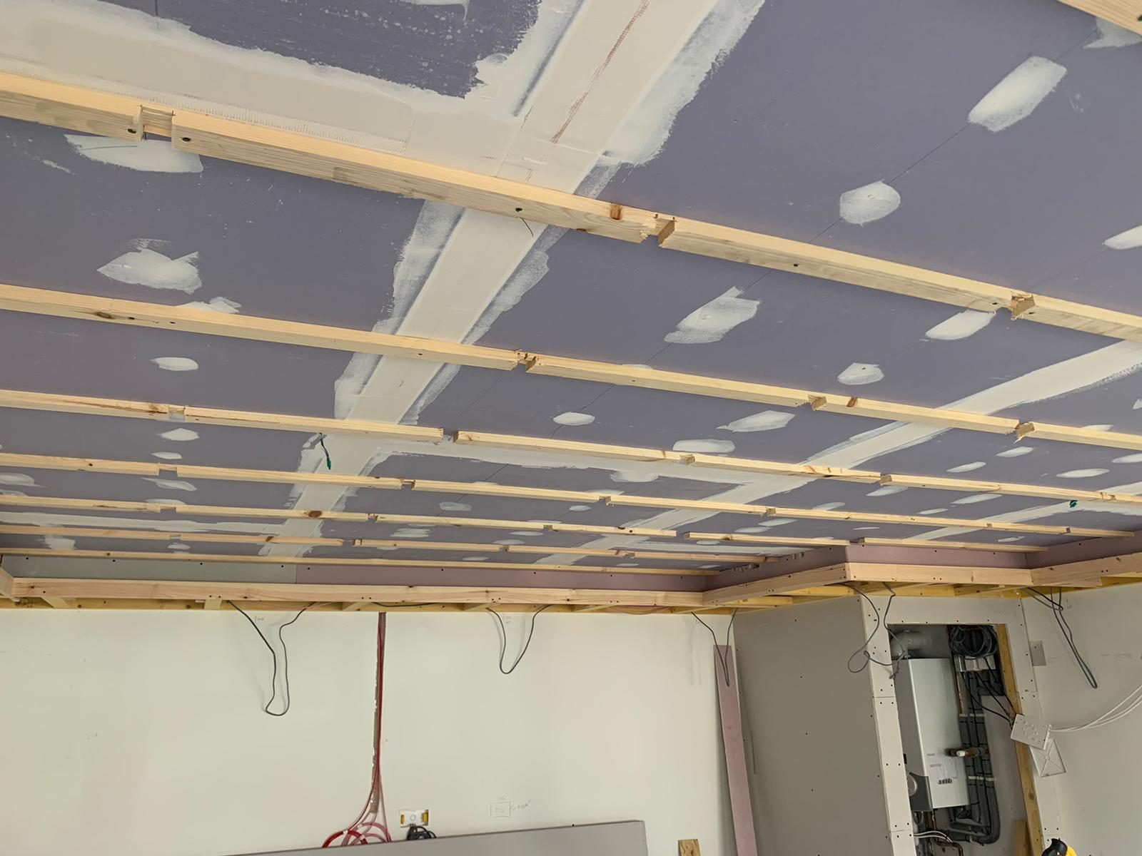 Bare garage ceiling framing before conversion