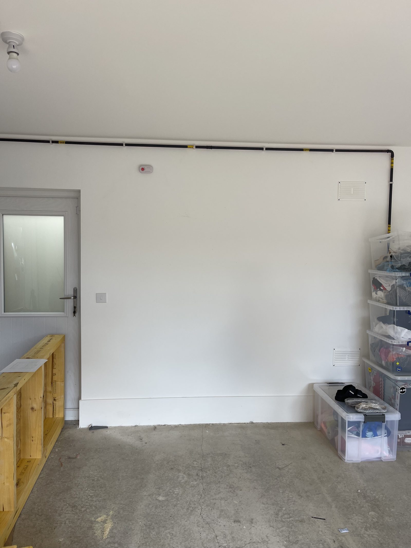 Bare plastered garage wall before conversion