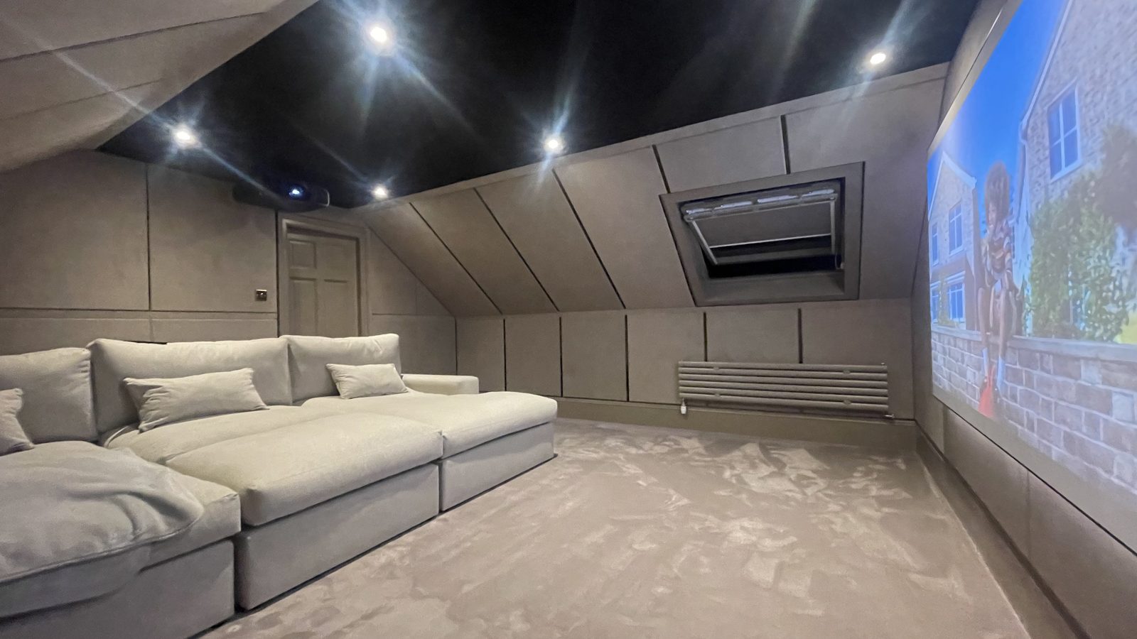 Finished Ayrshire attic home cinema, sofa and screen wall with football on screen