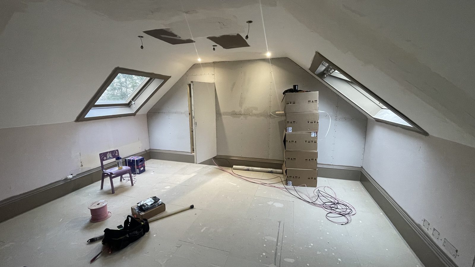Bare attic room with two skylights before cinema conversion, wide view
