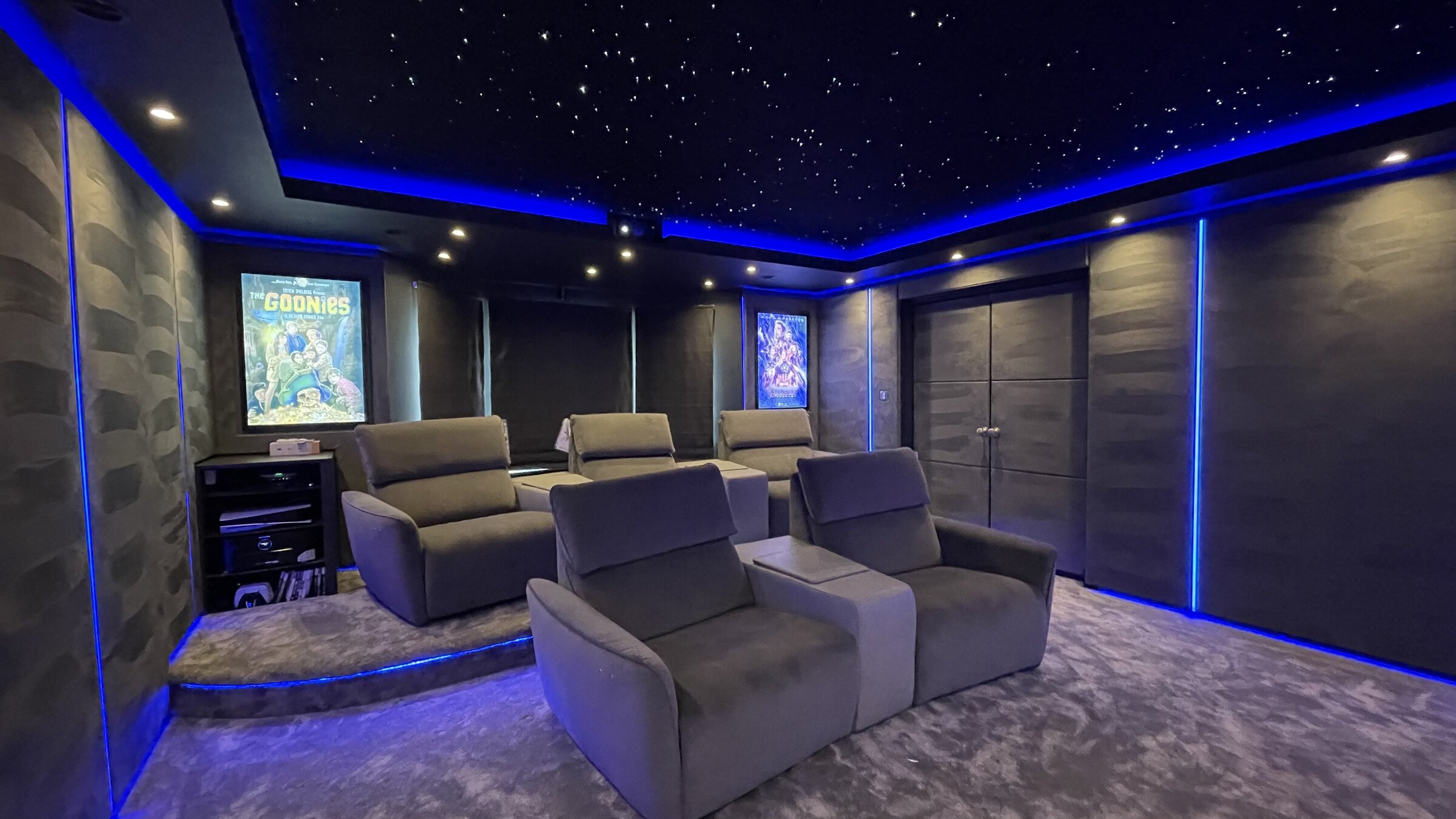 Finished dining room home cinema with tiered reclining seats, star ceiling and movie posters