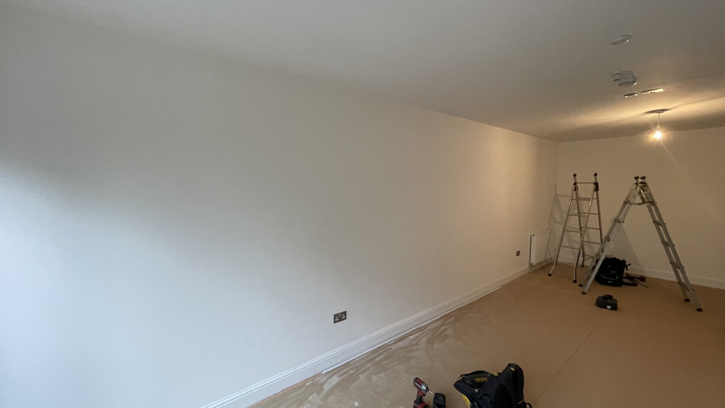 Bare penthouse room mid-strip before cinema conversion, ladders and exposed ceiling
