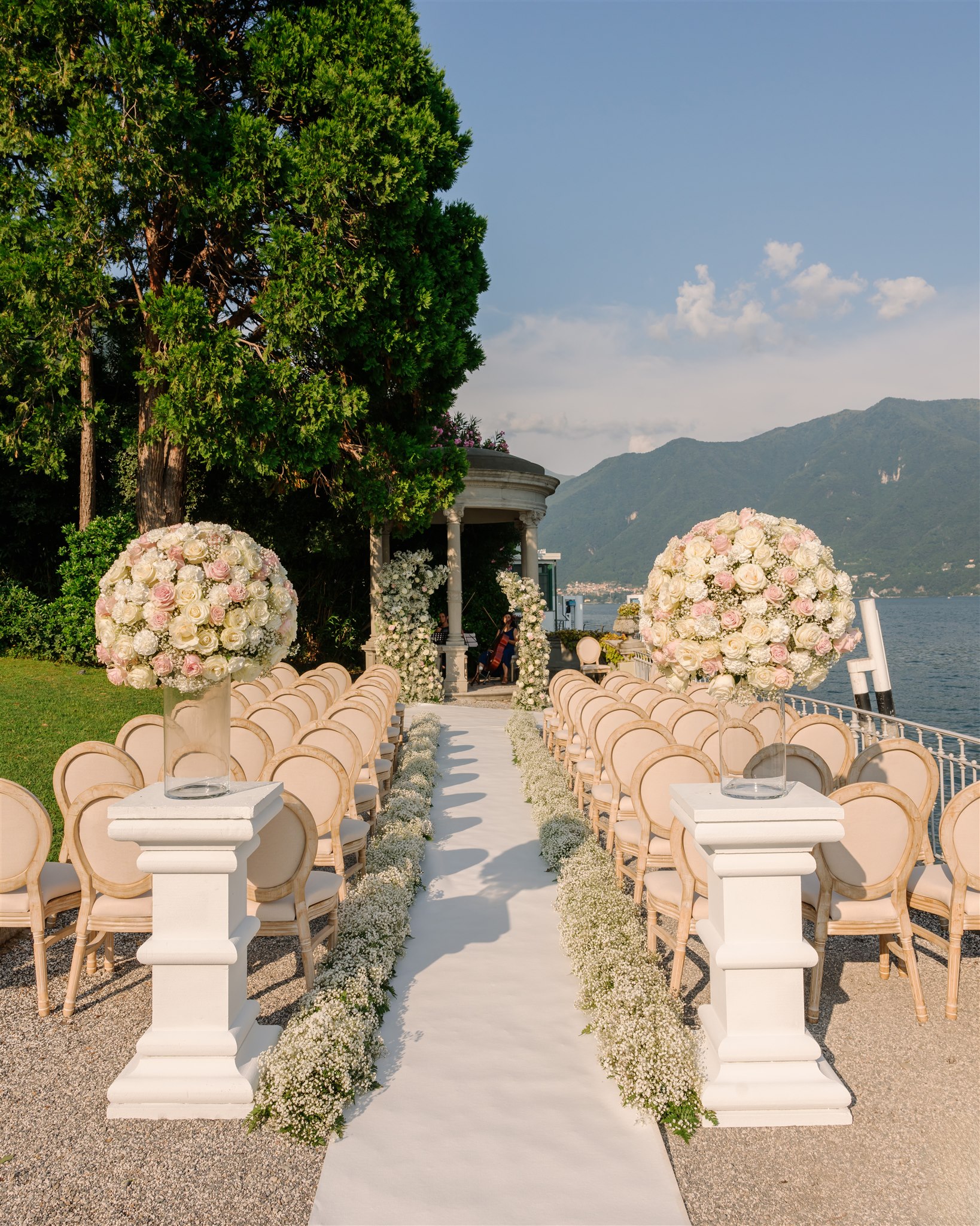 Wedding ceremony setup overlooking Lake Como with elegant floral arrangements