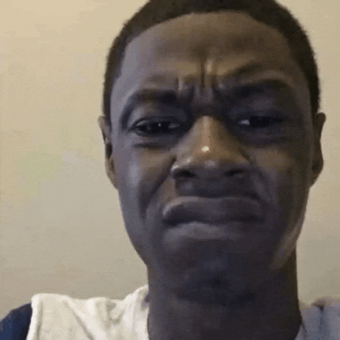 A young man making an awkward, uncomfortable facial expression with furrowed brows and a slight grimace.