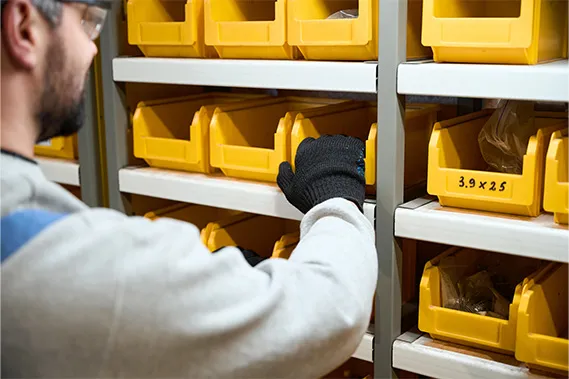 Ein Mann sortiert Artikel im Kleinteilelager.