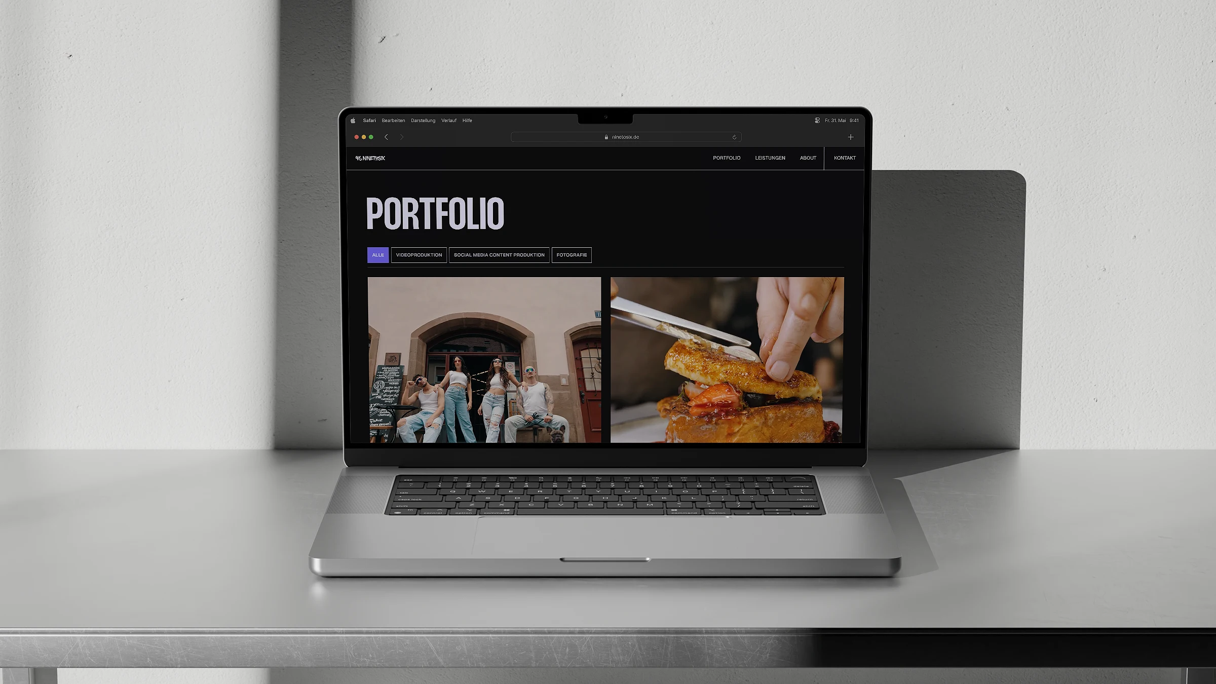 Laptop auf einem Tisch zeigt eine Portfolio-Webseite mit Bildern von Menschen vor einem Gebäude und einer Person, die Essen zubereitet.