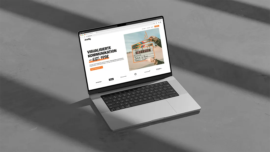 MacBook Pro mit geöffneter Website, die visuelle Kommunikation und ein Filmklappe-Bild zeigt.