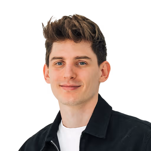 Porträt eines jungen Mannes mit braunen Haaren, weiße T-Shirt und schwarze Jacke, vor schwarzem Hintergrund.