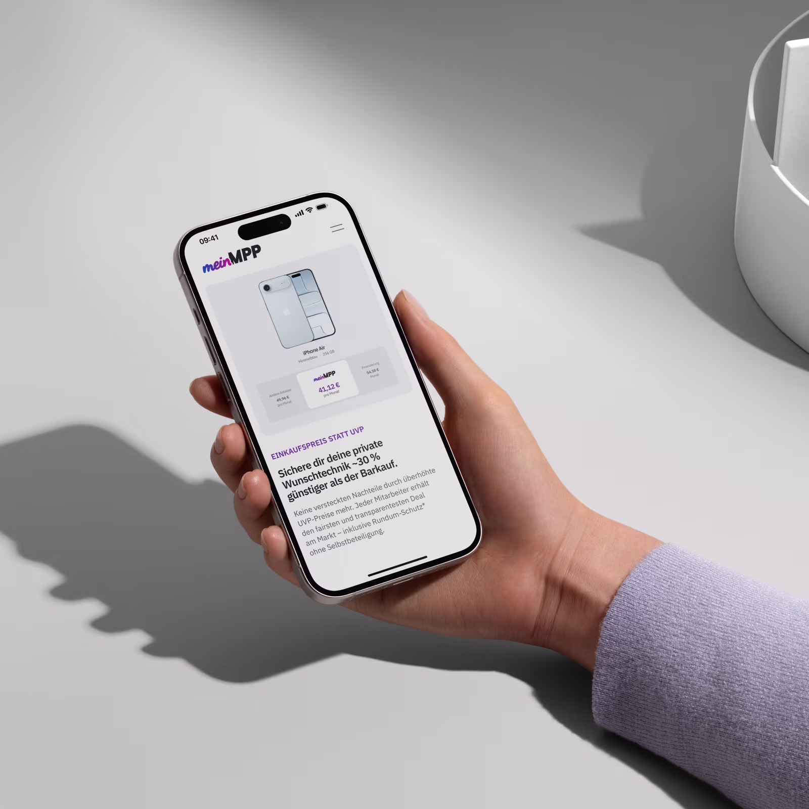 Hand hält ein Smartphone mit der meinMPP-App, die den günstigeren Preis für ein iPhone Air anzeigt.