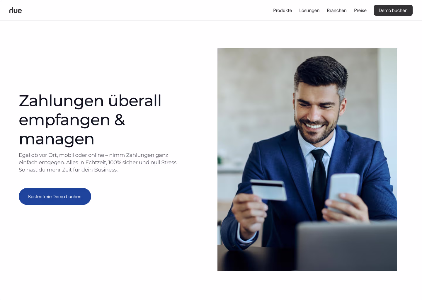 Lächelnder Mann im Anzug hält Kreditkarte und Smartphone, bereit für Online-Zahlung.