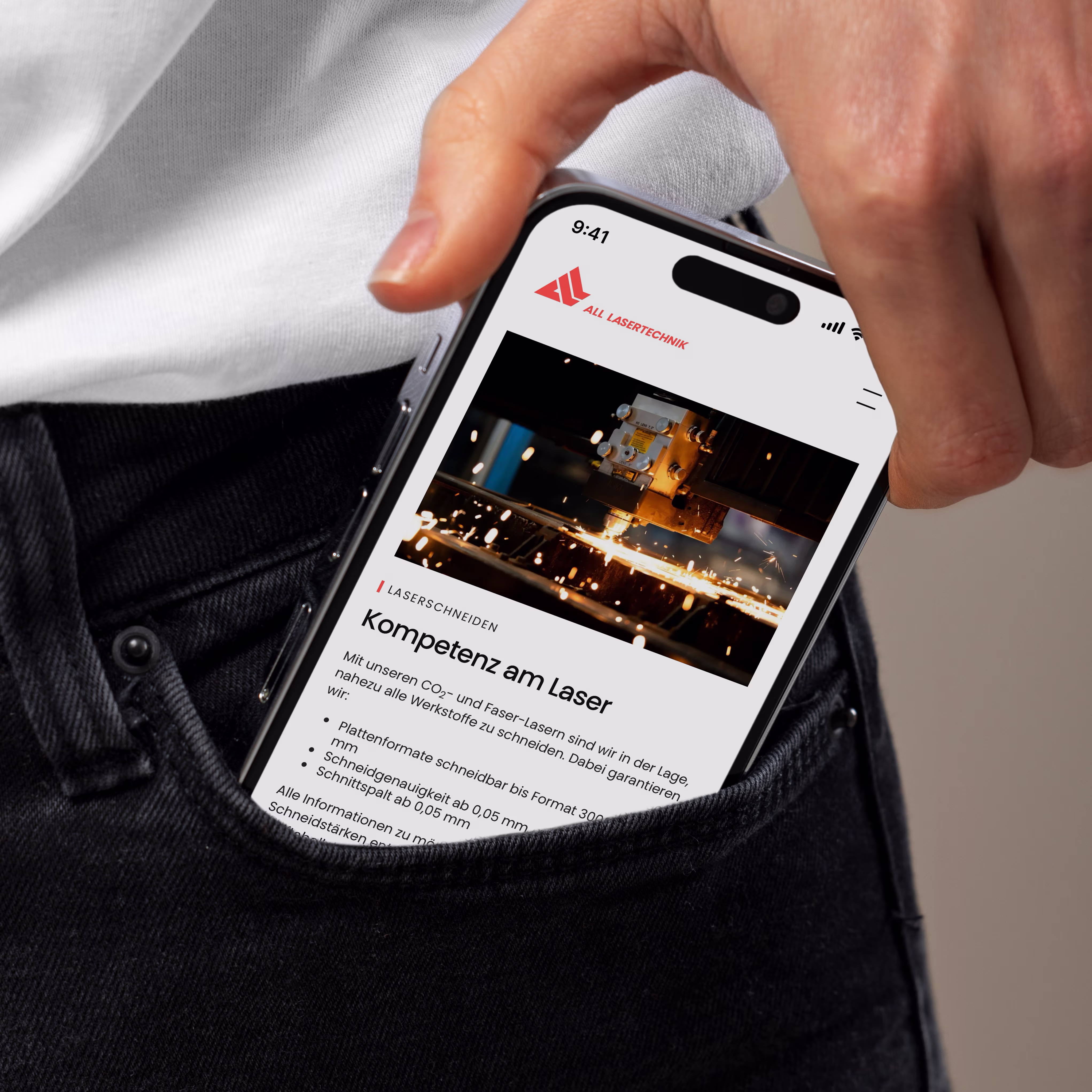 Smartphone zeigt Webseite von ALL LASERTECHNIK mit einem Bild einer Laser-Schneidemaschine und Text zu Laserschneide-Kompetenz.