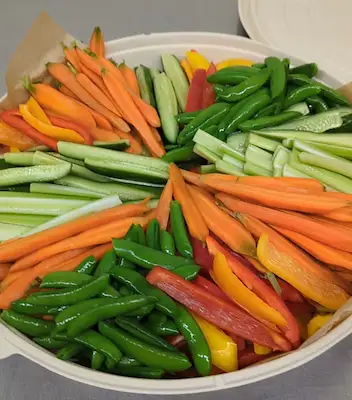 A cardboard platter filled with a rainbow pinwheel of veggie sticks