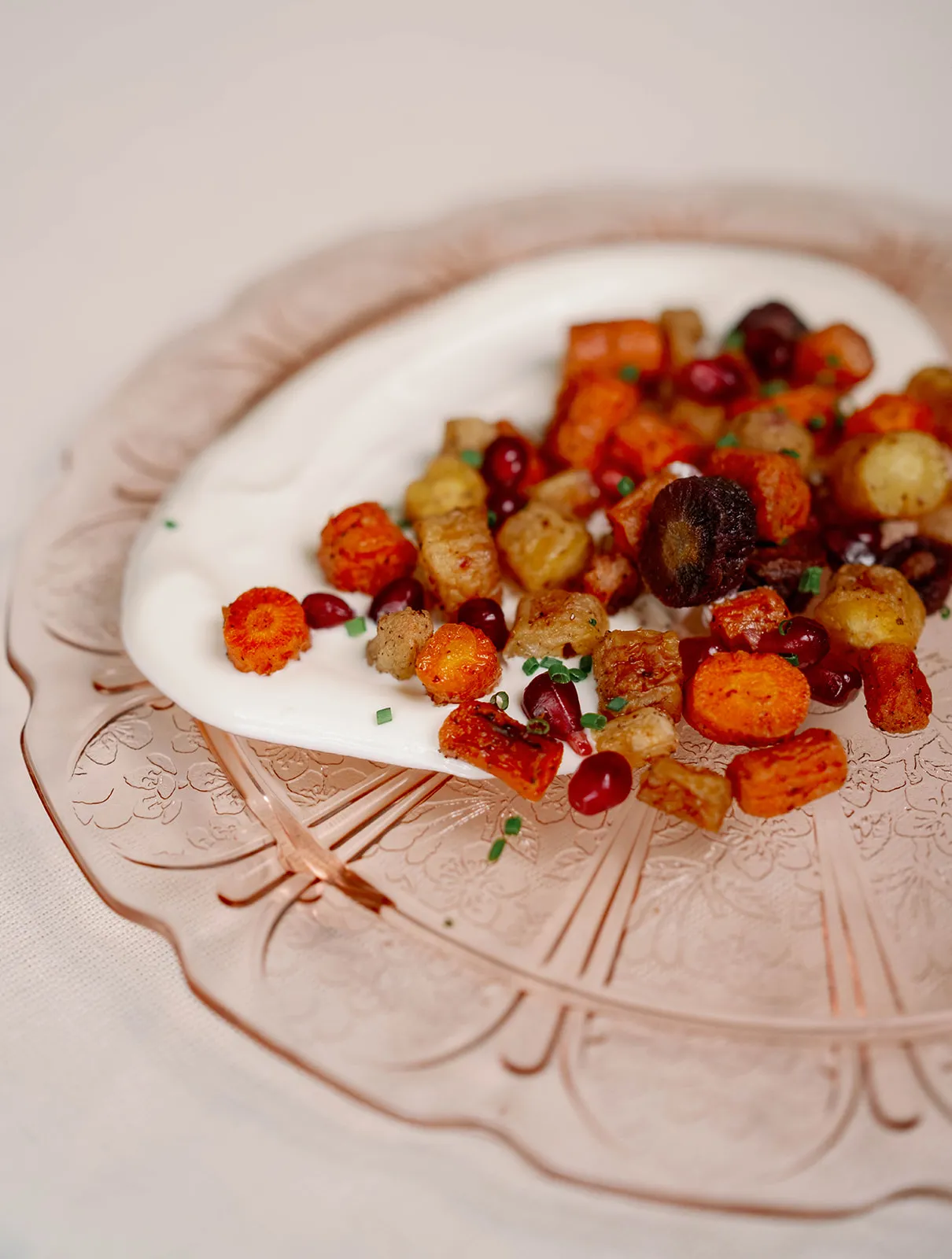 Morrocan roasted carrot salad- roasted rainbow carrots tossed in a honey sumac glaze, and served with pomegranate seeds and fresh herbs, served over labneh