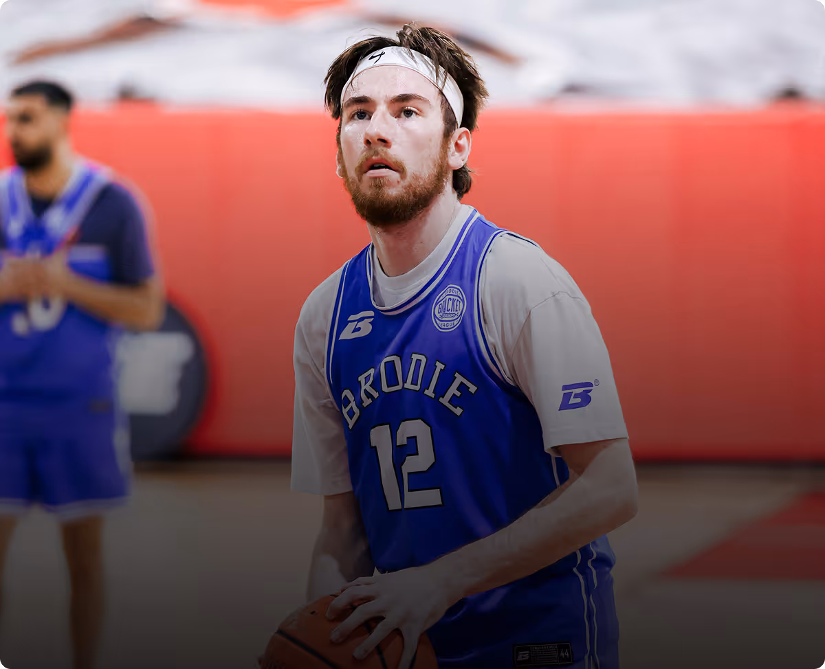 Basketball player wearing number 12 Brodie blue jersey preparing to shoot a free throw.