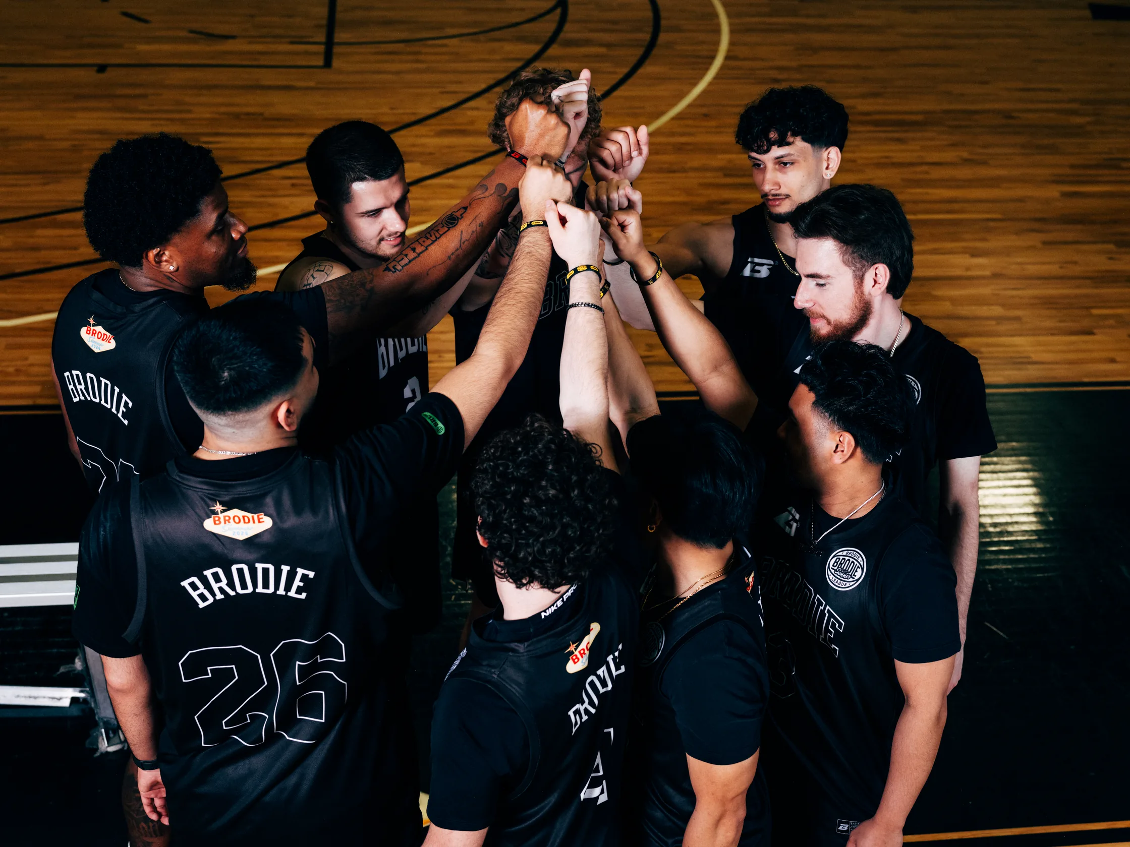 Brodie team in a huddle, hands in