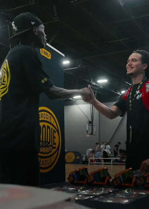 Brodie League Manager shaking hands with an athlete at check-in