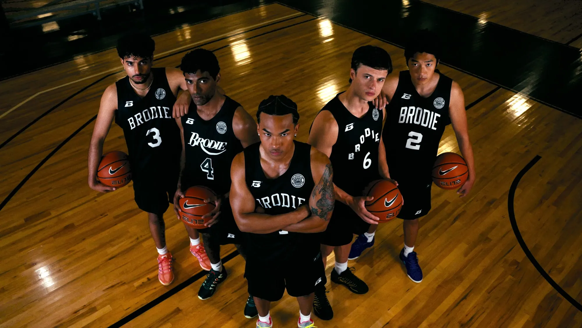 Brodie team in black jerseys lined up on court