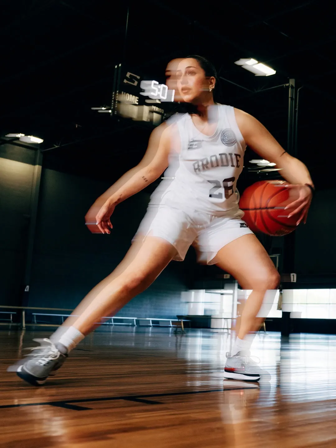Brodie athlete driving to the basket in a white jersey