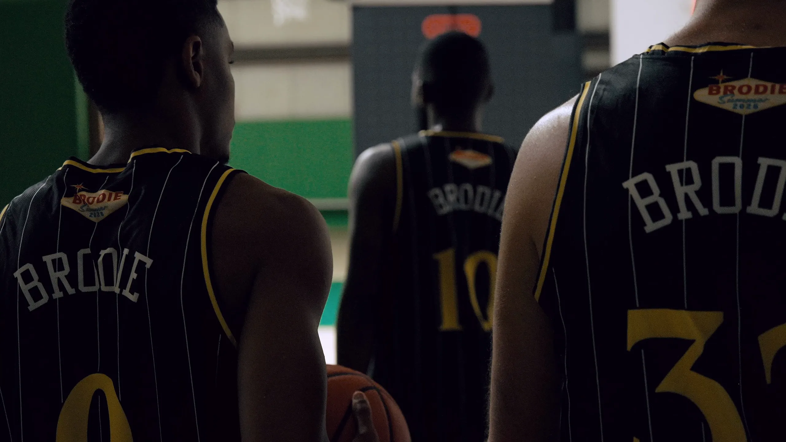 BRODIE athletes walking onto the court at the Walpole venue, seen from behind