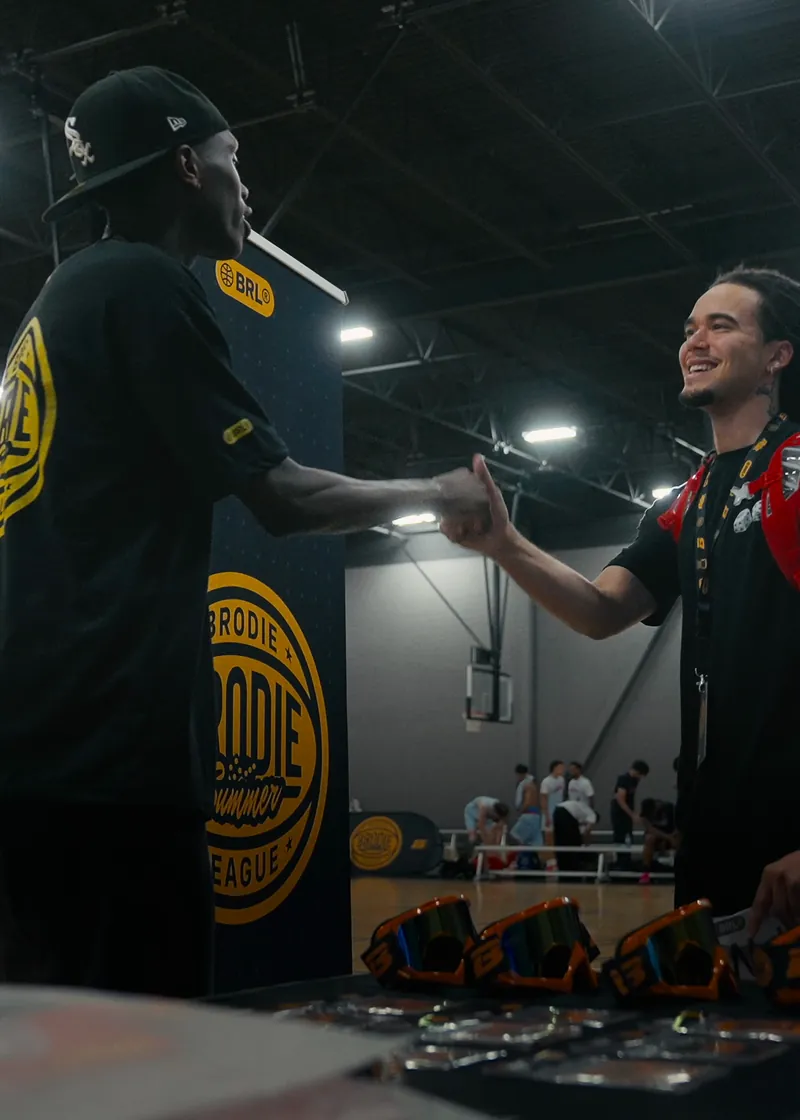 Brodie League Manager shaking hands with an athlete at check-in