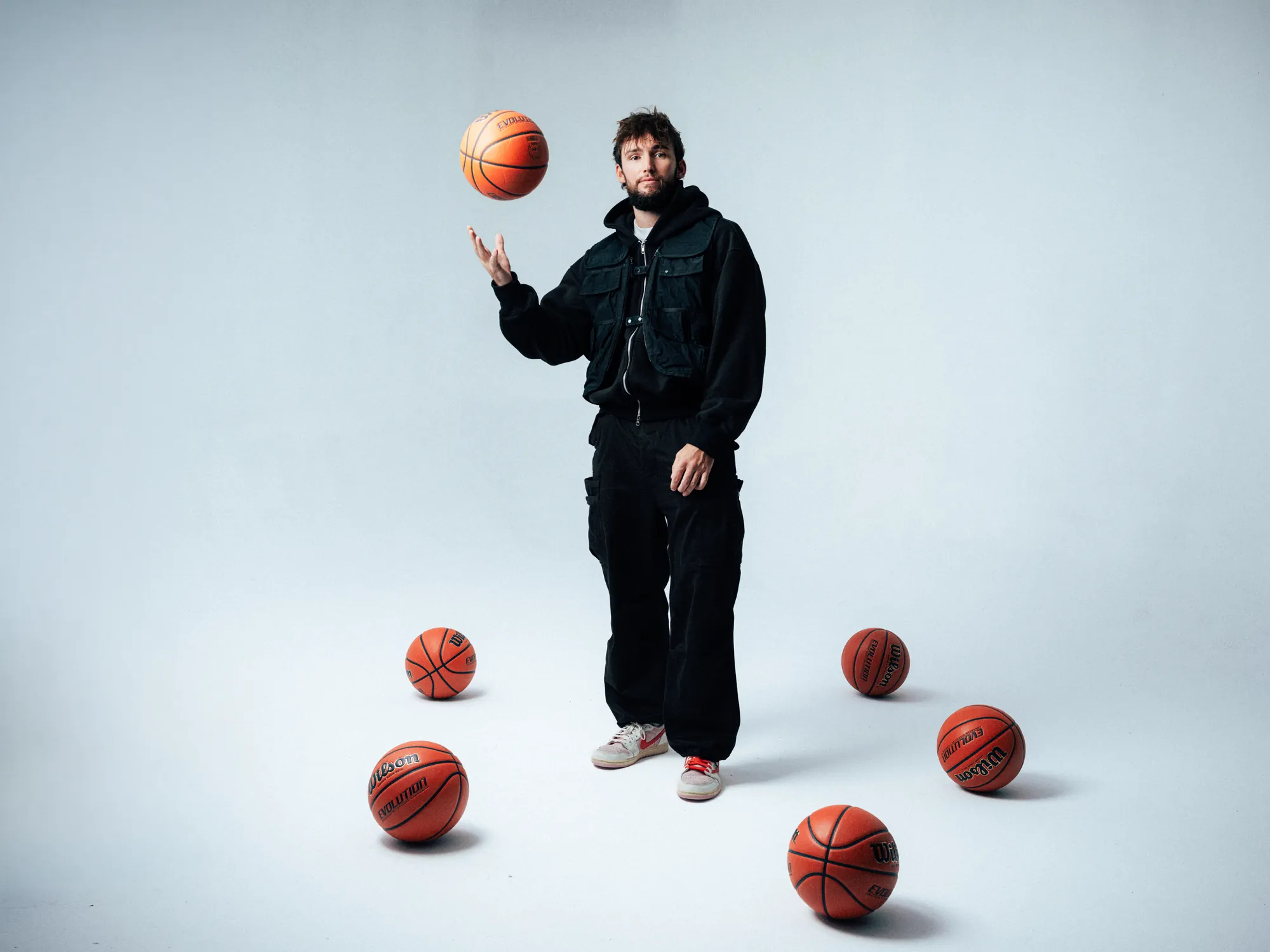 Connor Renton, founder of BRODIE, sitting on a director's chair holding a basketball