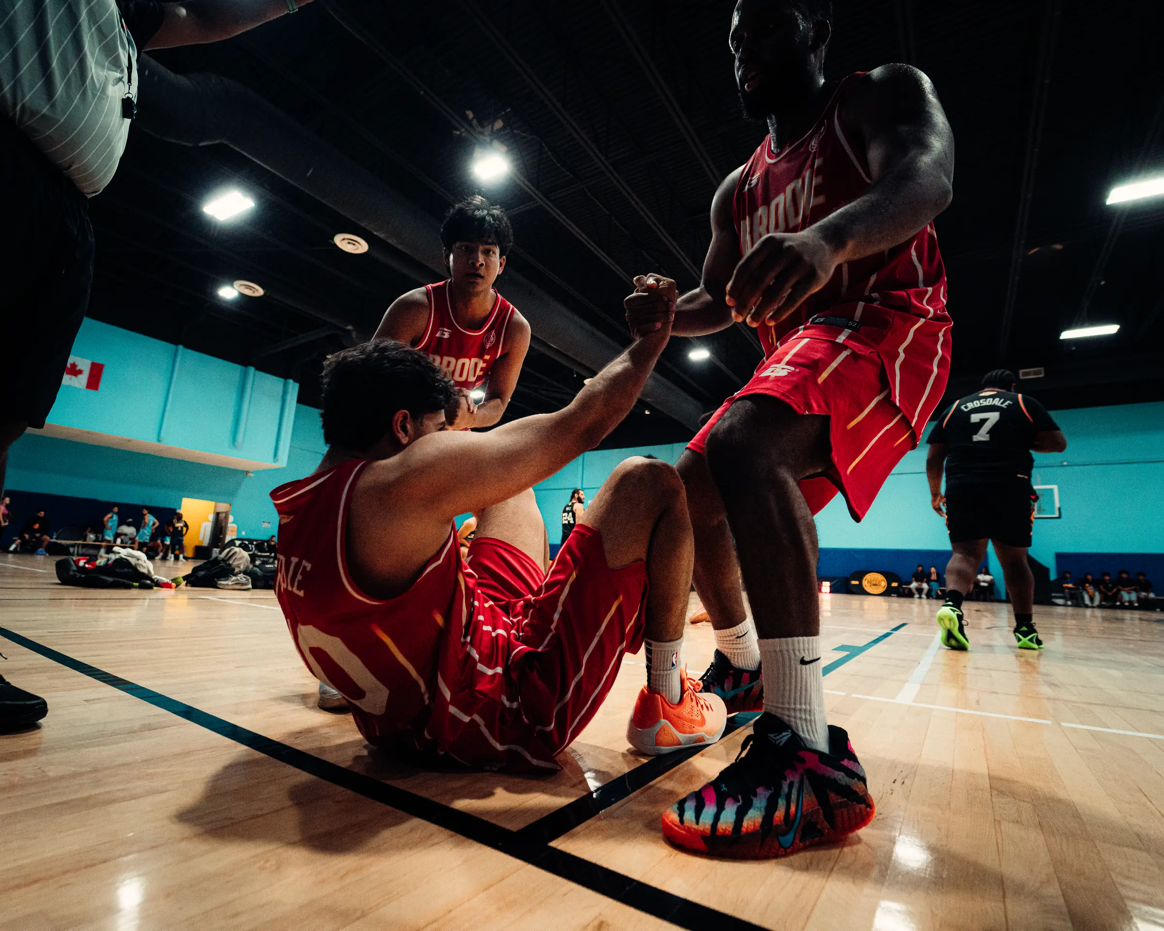 BRODIE athletes in red jerseys celebrating together on court
