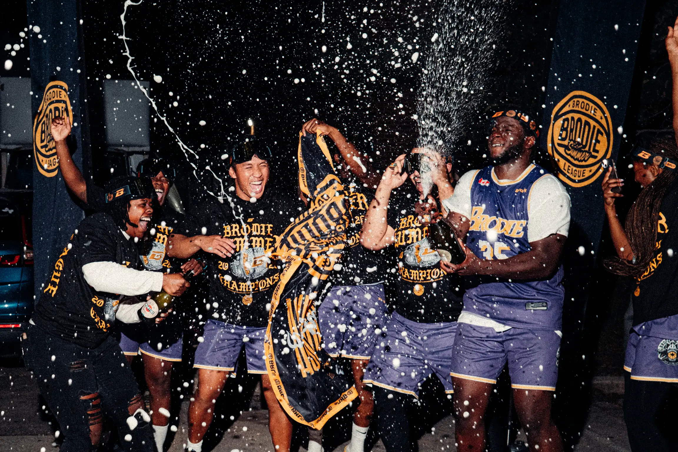 BRODIE Summer League champions spraying champagne in their goggles