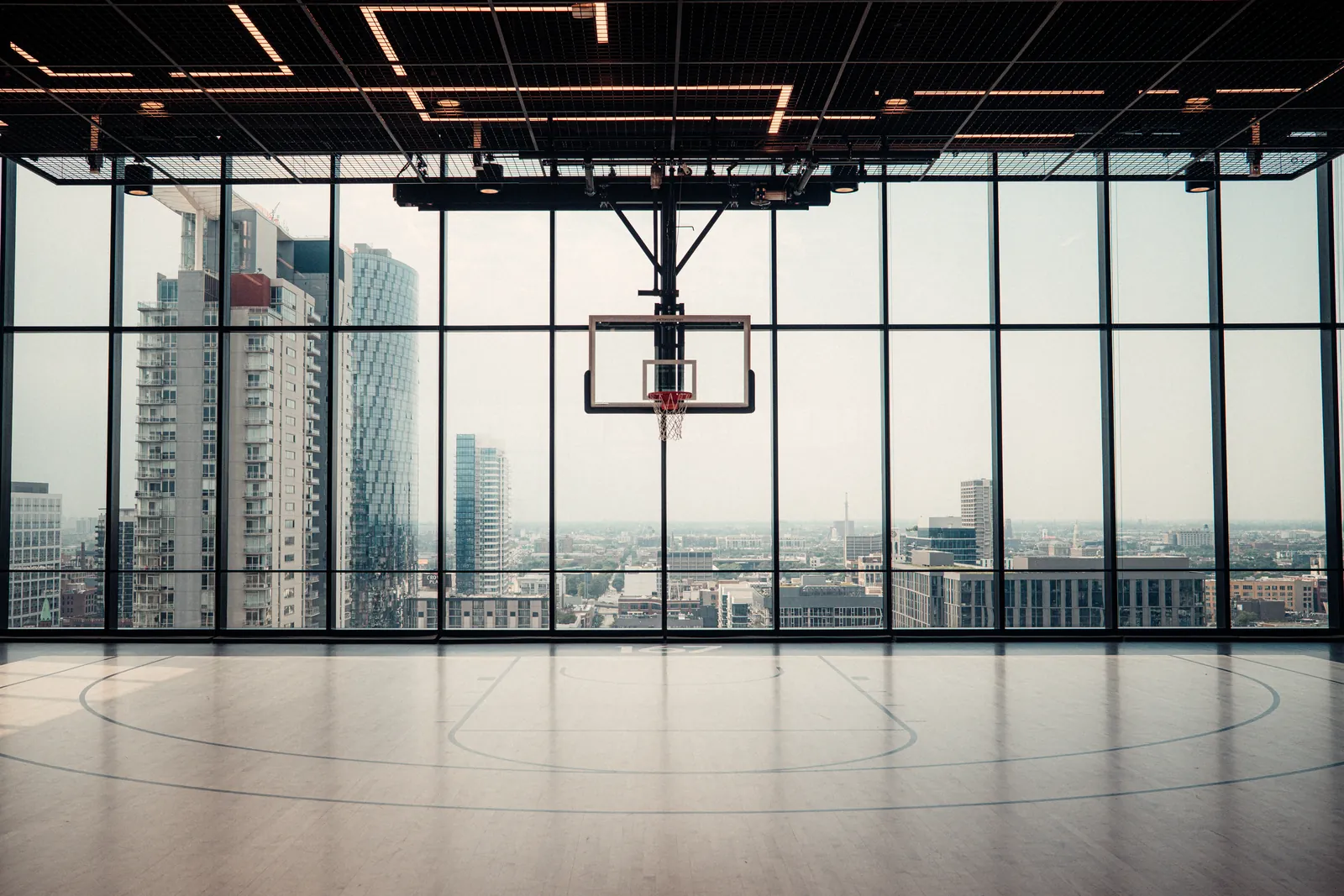 Empty BRODIE court with floor-to-ceiling windows over a city skyline
