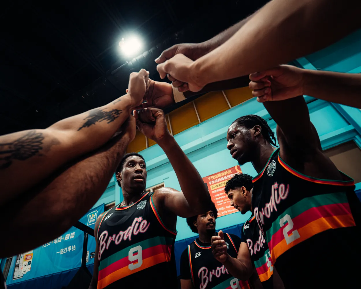 BRODIE teammates stacking their fists in a huddle