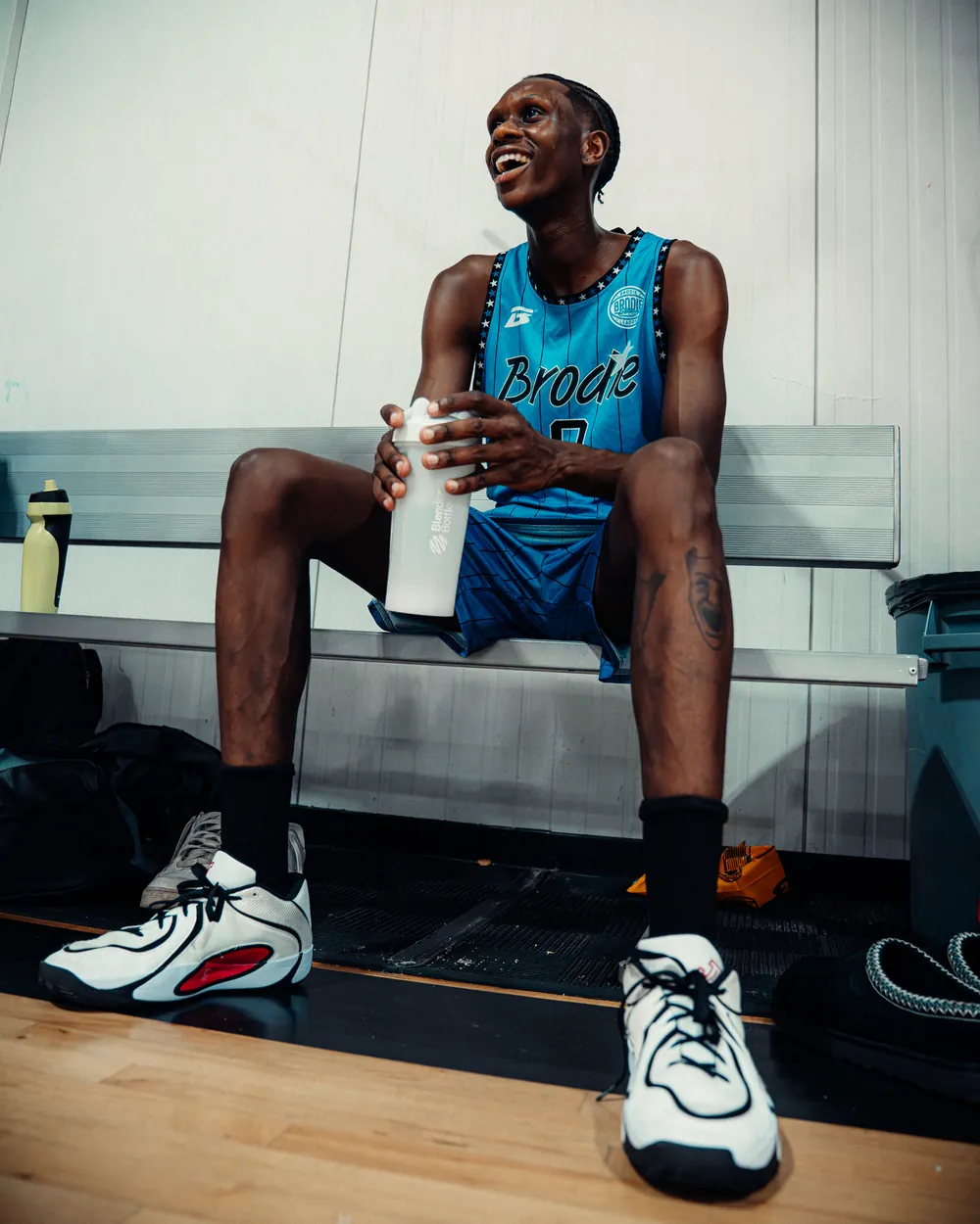 BRODIE athlete laughing on the bench courtside