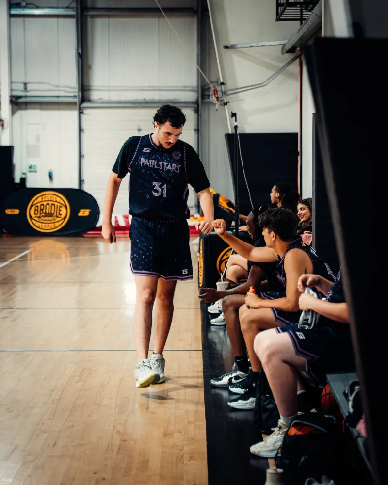 BRODIE player walking the sideline past the bench