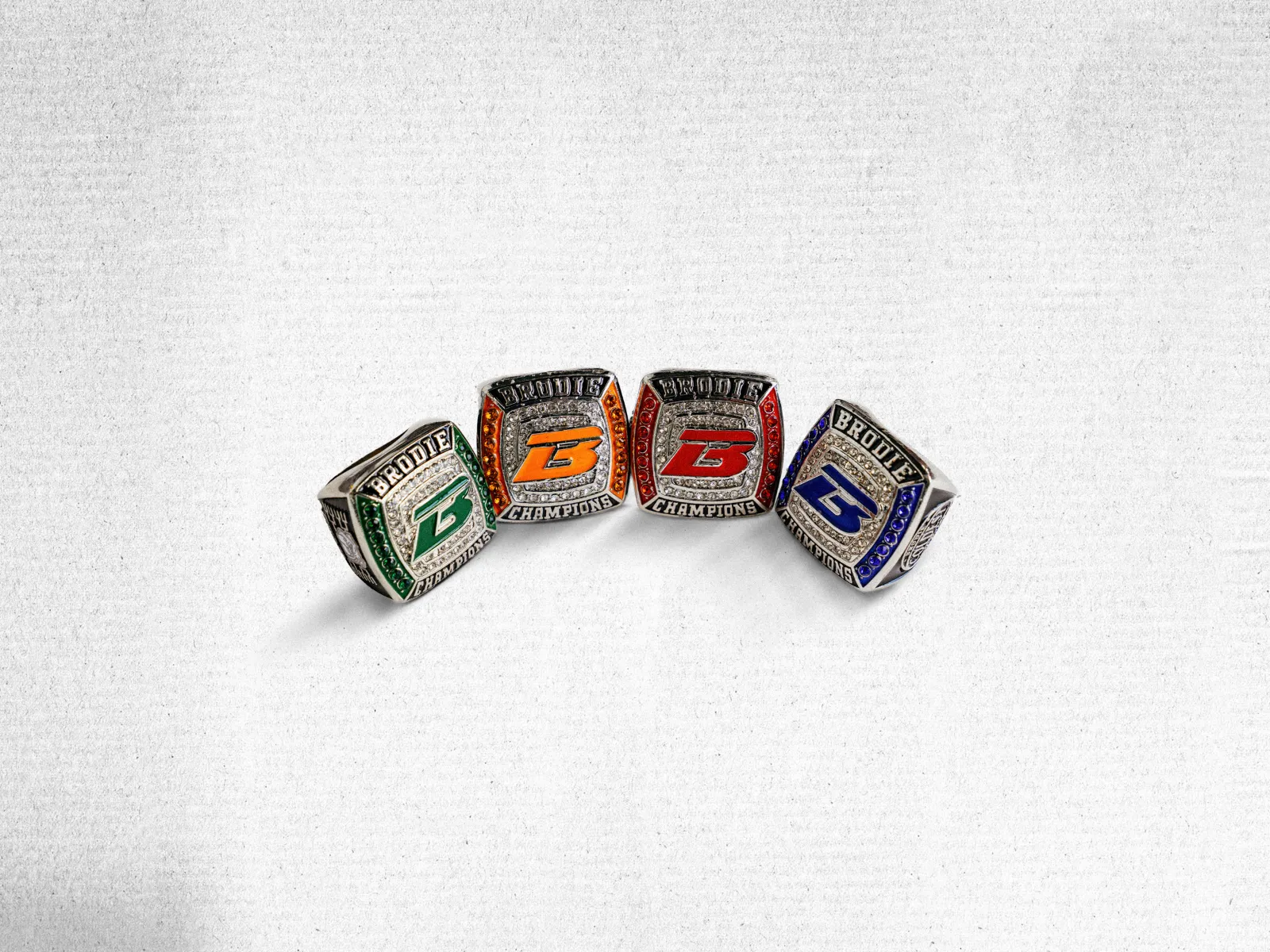 Four Brodie championship rings in each season's colours