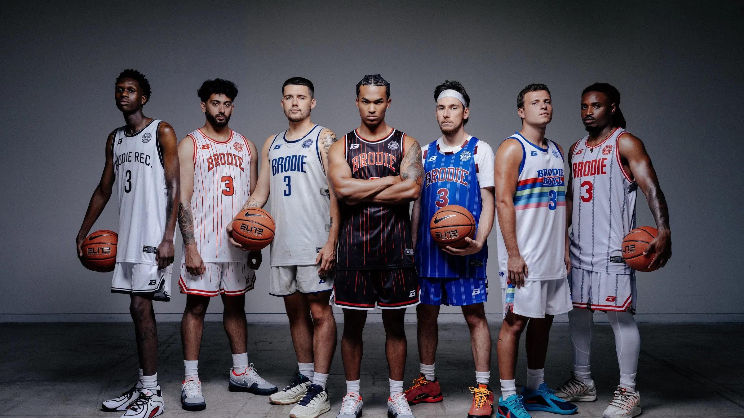 Seven BRODIE® athletes in different team jerseys, each holding a basketball