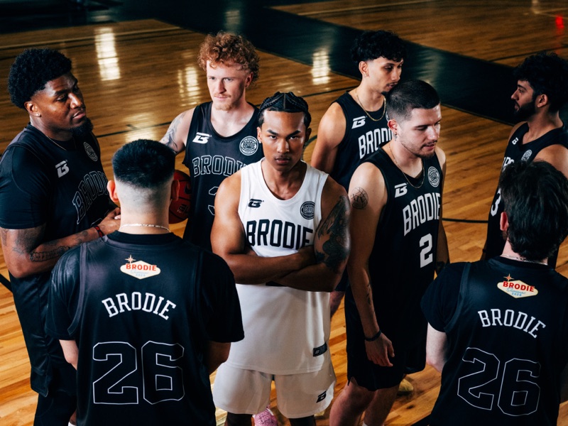 Brodie players huddled on court in team jerseys