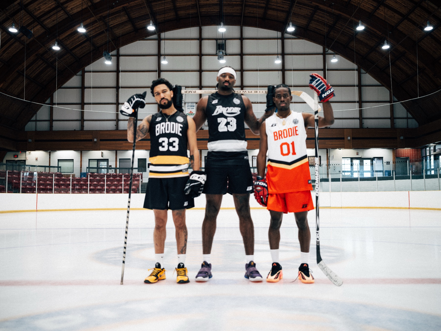 Three BRODIE athletes in jerseys on the ice at a rink