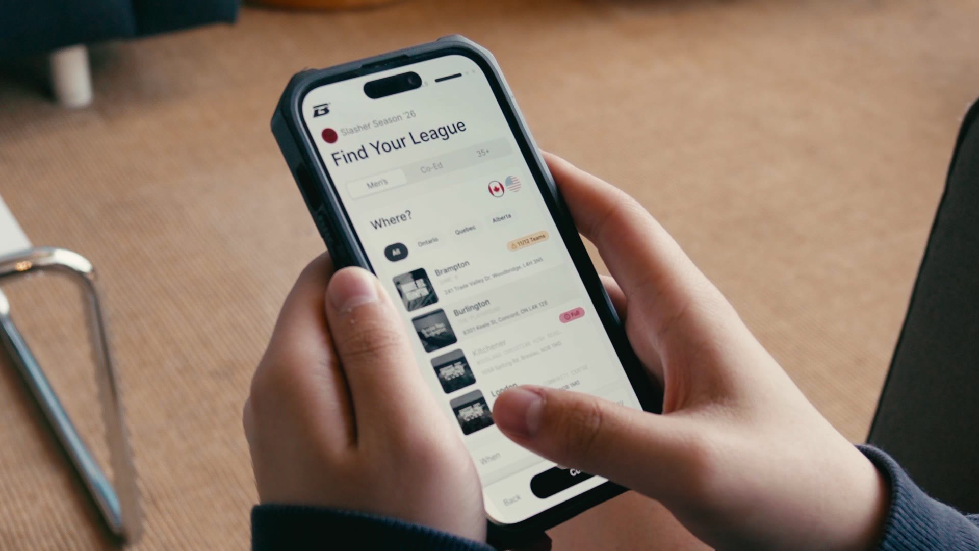 Hands holding a phone showing the Brodie Find Your League screen