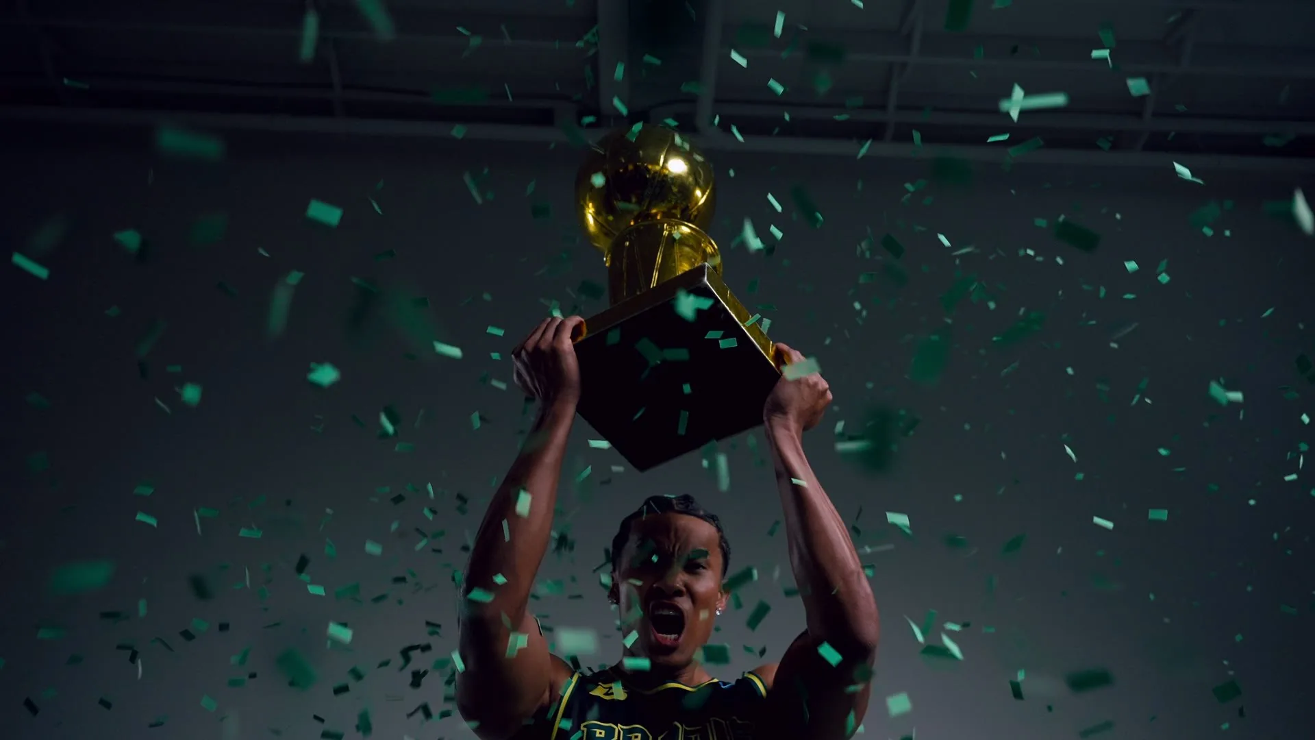 Athlete raising the championship trophy as green confetti falls