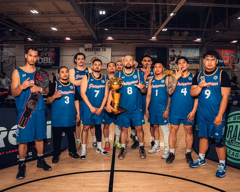 A Brodie team in teal jerseys poses with the championship trophy and belt