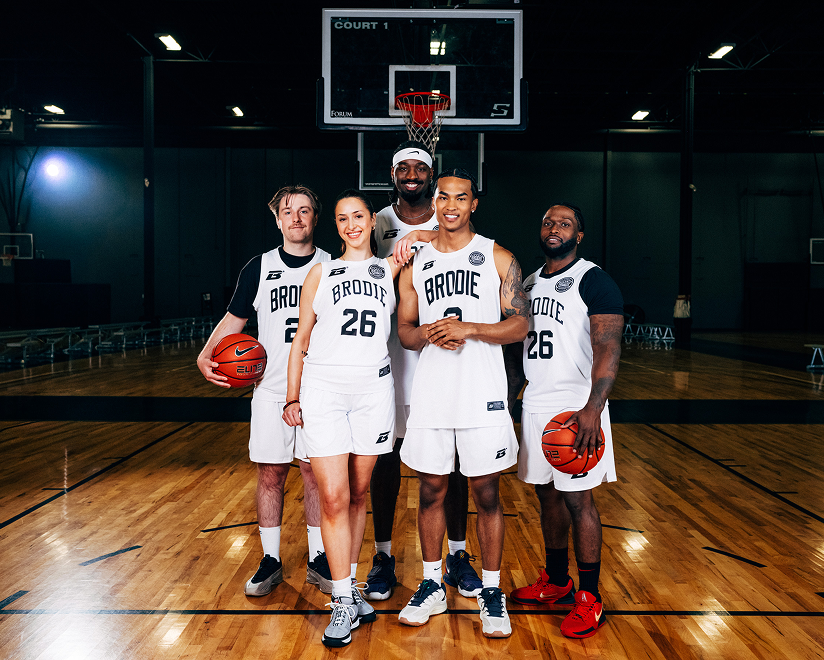 Four Brodie athletes in white and black jerseys on a court