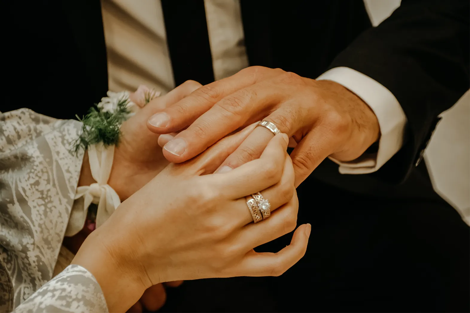 Frau steckt dem Mann bei der Hochzeit einen Ring an