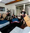 Payable Moving Company crew packing and wrapping furniture inside a modern home during a professional move.