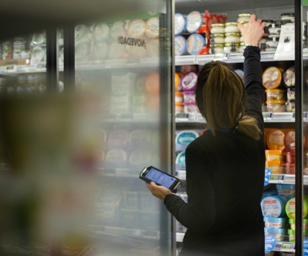 employé de rayon qui vérifie les dates courtes avec une solution smartway à la main