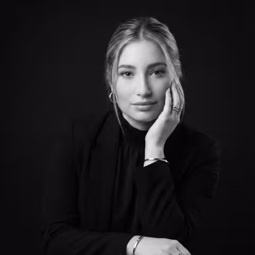 Retrato en blanco y negro de una mujer joven con cabello recogido, apoyando la cabeza en su mano y mirando al frente con expresión serena.