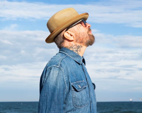 Head and shoulders of Dave Stewart looking at sky on beach
