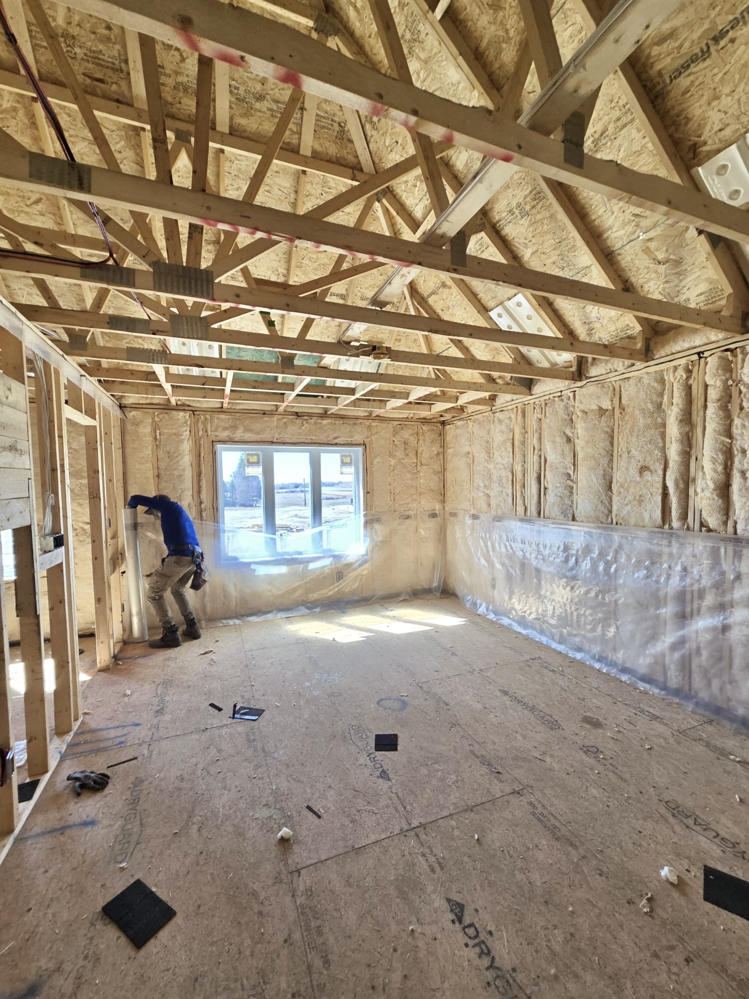 A worker installing insulation in a house on the wall