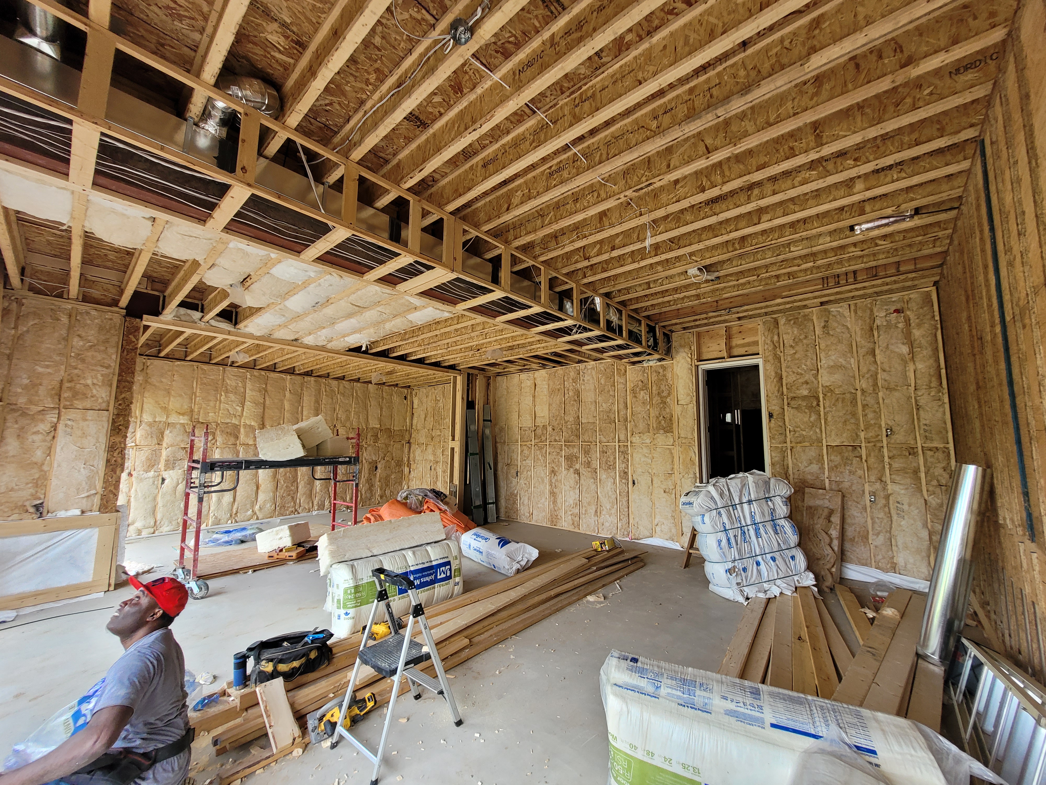 A large house under construction with some insulation installed.