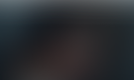 Blurred dark gradient background fading from dark blue to black.