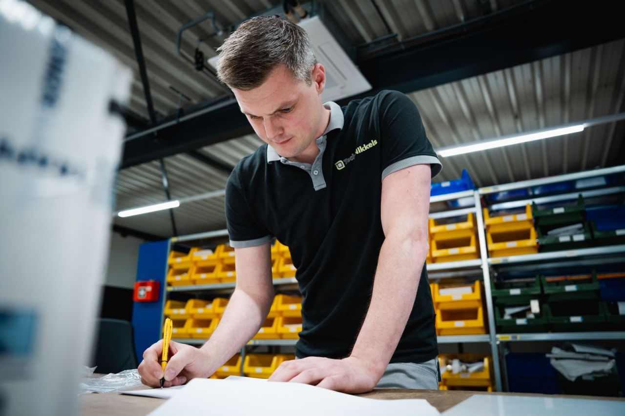 Medewerker van TechNikkels bij een verpakkingsmachine