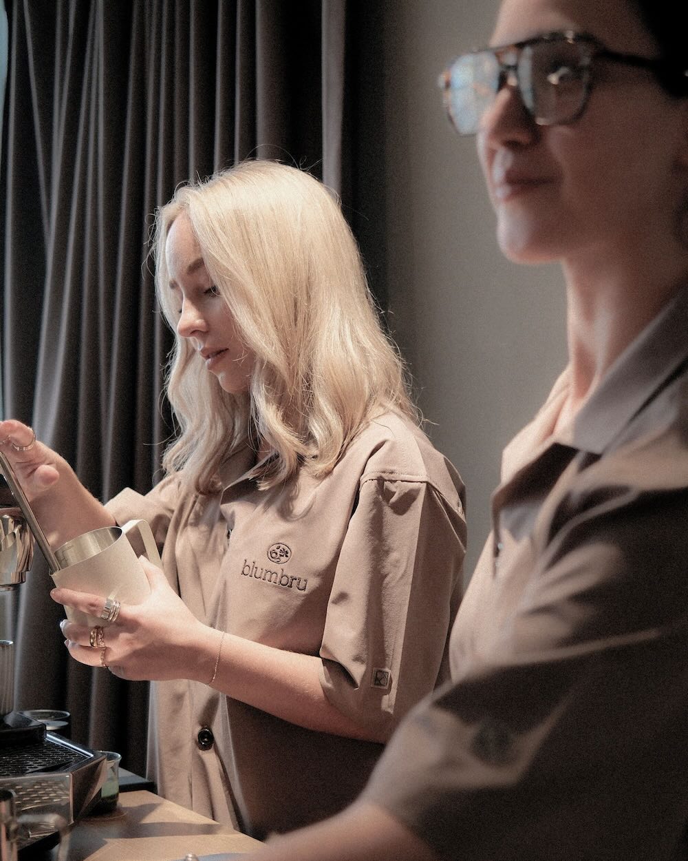 2 baristas working behind coffee catering cart.